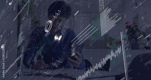 Data arriving, seated pro consulting phone and noting while analyzing charts sliding up to gains