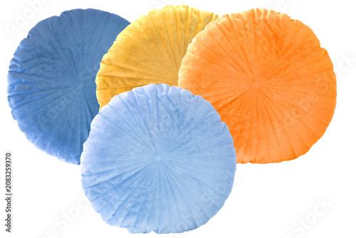 Collage set of four colorful round pillows isolated. Blue and yellow soft cushion. Pillows with decorative fluffy cover. Top view.