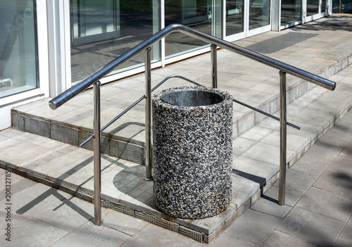Stainless steel handrail and waste container at the entrance to the building