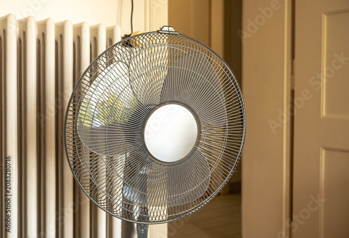 Close up of a metal electric fan grill in a residential room