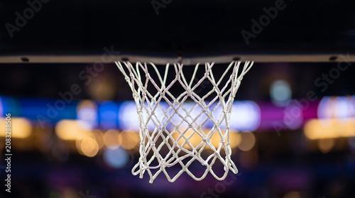 Close-up of a basketball net with colorful bokeh stadium lights in the background