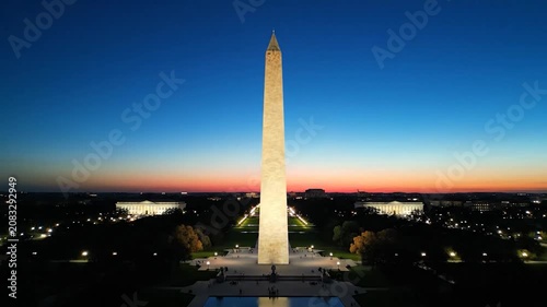 The tall stone obelisk stands against a colorful sunset sky