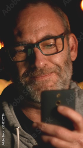 Smart handsome adult man use his smart phone outside in the city. Using smartphone technology makes him smiling happy wearing urban outfit. vertical video