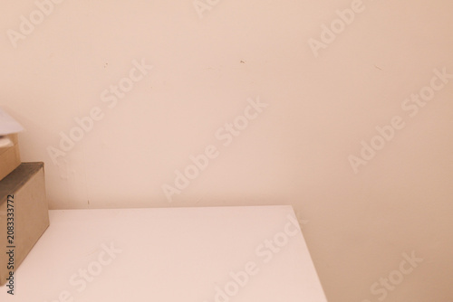 A plain wall and a table show boxes arranged on the surface, creating a simple room scene