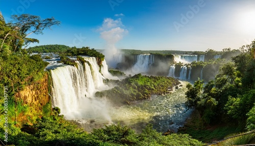 panoramic scenic view of iguazu falls with mist and lush green tropical forest on a sunny day misiones province argentina