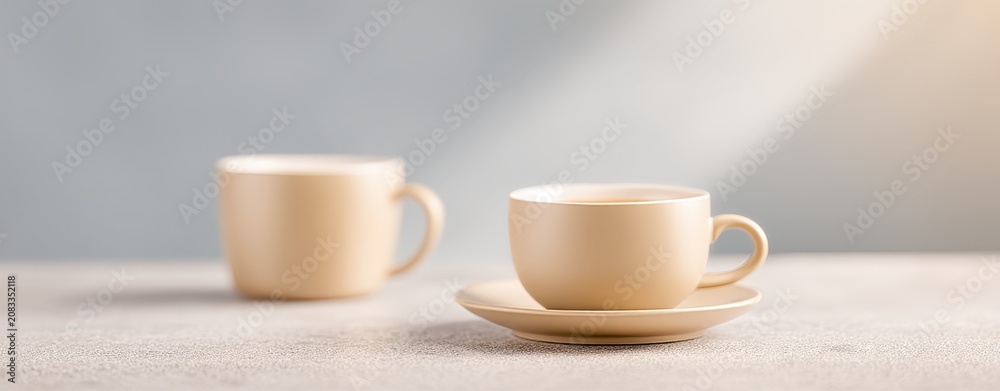 Fototapeta premium Cute Tea Party Wallpaper Elegant Minimalist Cream-Colored Coffee Cups with Saucer on Light Textured Surface and Soft Natural Lighting a magical fairy tea party minimalist cute tea party wallpaper