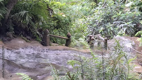 Stunning natural white limestone cascades at Bua Tong Sticky Waterfalls in a lush forest setting, Chiang Mai, Thailand.