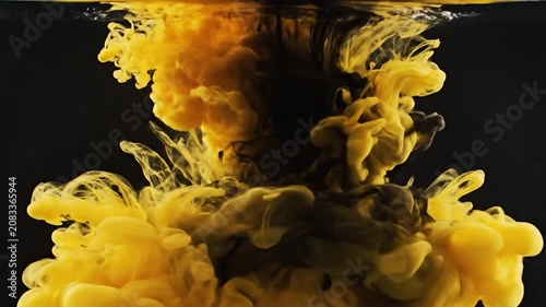 Yellow and black ink clouds swirl in dark water