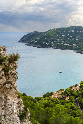 Aerial view of sailboats and yachts anchored in peaceful bay near resort town of Canyamel, Mallorca. Mediterranean coastline, turquoise sea, luxury travel and summer vacation concept.