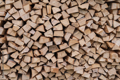 Neatly stacked split firewood logs with natural wood texture for heating and rustic background