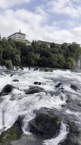 Schaffhausen, Switzerland - October 11, 2025: View of the Rhine Falls, Europe’s largest waterfall, with powerful cascades and the surrounding landscape on an autumn day.