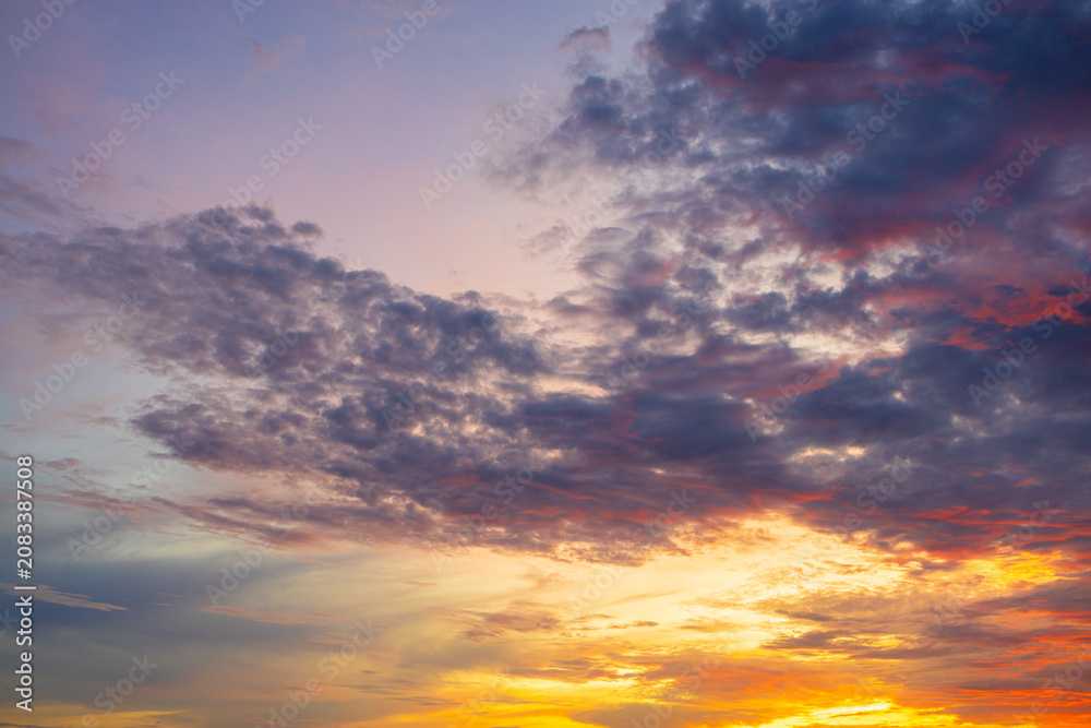 Fototapeta premium Dramatic Sunset Sky with Fiery Clouds,A breathtaking view of a dramatic sunset with vibrant orange and red clouds contrasting against a deep blue evening sky.