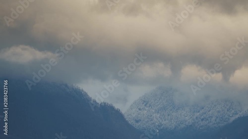 bad weather in the mountains, the peaks are covered with snow