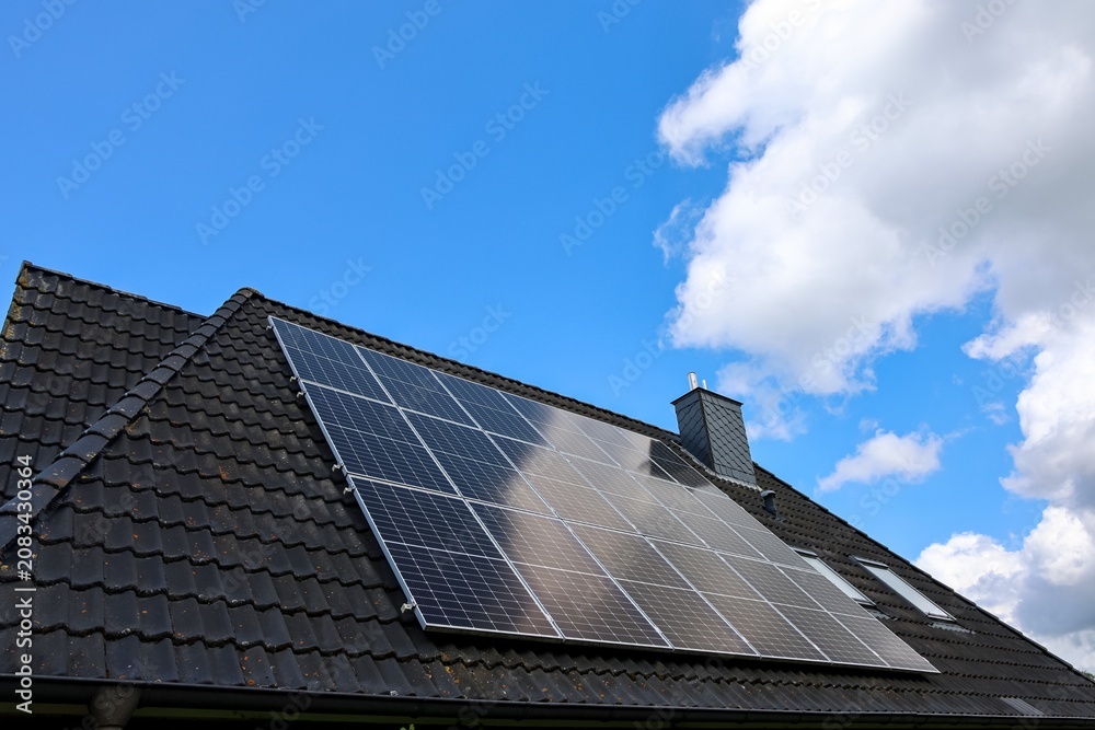Fototapeta premium Solar panels on house roof harvesting clean energy