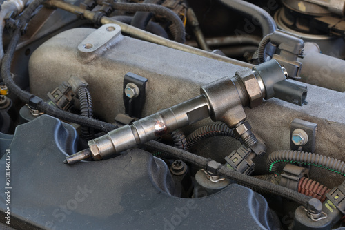 Detail of modern diesel engine repair, closeup of injector at engine after replacing, common rail system