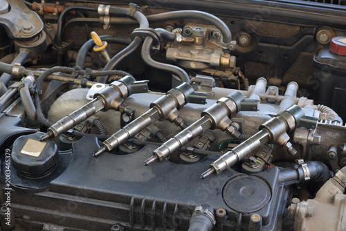 Detail of modern diesel engine repair, closeup of injector at engine after replacing, common rail system