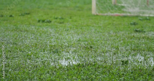 Heavy rain causing flooded water on green soccer field grass