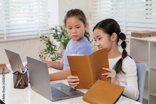 Canvastavla Preteen asian student reading notebook smiling while caucasian classmate sitting