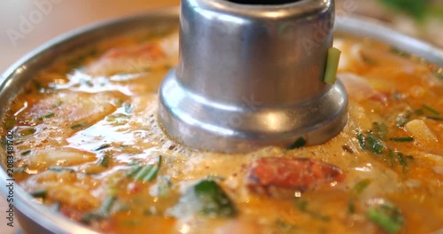 Close up of Tom Yum Goong hot and sour soup boiling in Thai hot pot