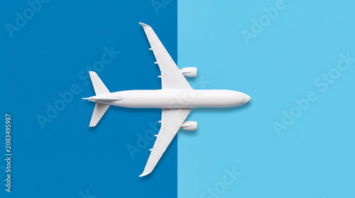White passenger airplane flying against blue sky background