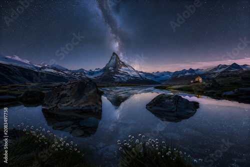 Majestic Alpine Peak Under the Milky Way Reflected in a Tranquil Mountain Lake at Night