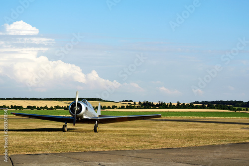 Airplane parking beside airport runway. This Airplane is a popular World War II-era training plane frequently seen at air shows and flying events today.