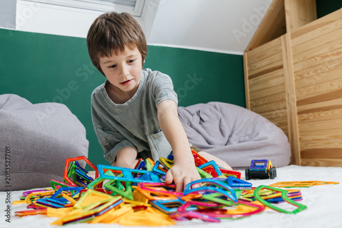 Принти на полотні Boy playing with colorful magnetic construction blocks on floor