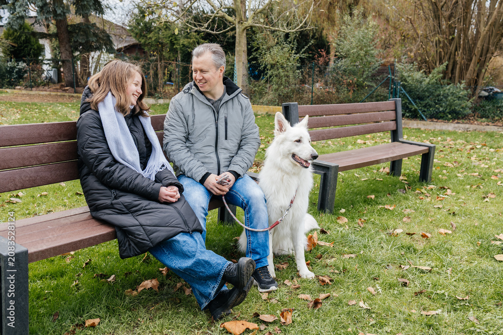 Fototapeta premium Father and daughter enjoying time with white shepherd dog