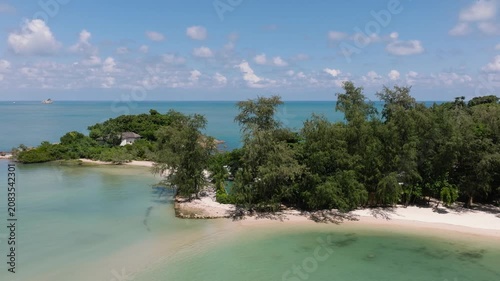 A serene island surrounded by turquoise water and lush greenery with a sandy beach. Cape Fahn. Koh Samui, Thailand.