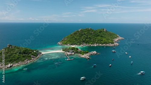 Two islands connected by a narrow sandy pathway surrounded by clear turquoise water. Nang Yuan, Koh Tao, Thailand.