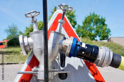 Картината върху платно Fire hose connected to standpipe beside warning sign