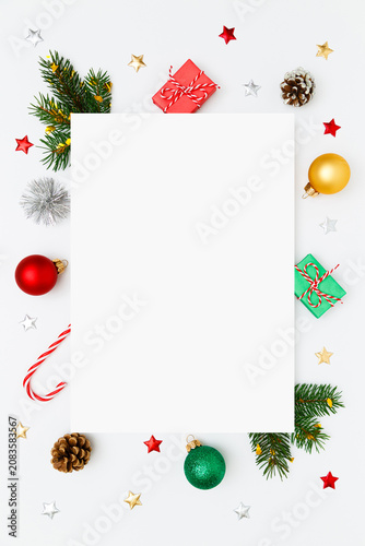 Christmas, New Year vertical frame of fir tree branches, gifts, decorations, balls, candy canes, stars on white flat lay background. Perfect for holiday greetings, banners, social media. Copy space