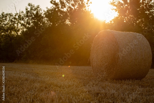 Sunset over a field with a hay bale in Bekes, Hungary, during the late afternoon hours