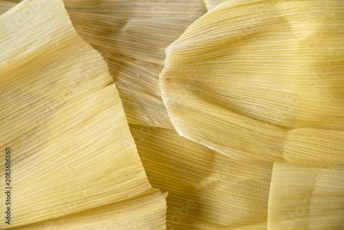 Background texture of dried corn husks used for cooking tamales. The texture appears fibrous and rough, with subtle variations in color intensity.
