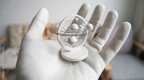 White hand holding a black and white globe
