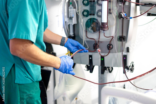 Medical professional preparing dialysis machine for blood filtration