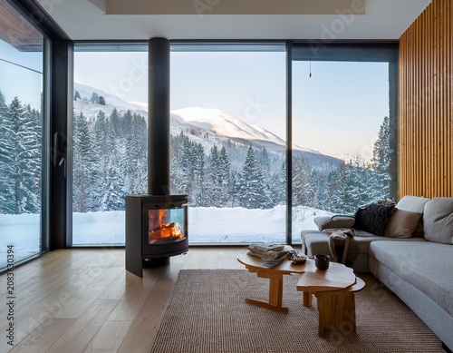 a modern living room with a wood burning stove and large glass window offering a snowy landscape view