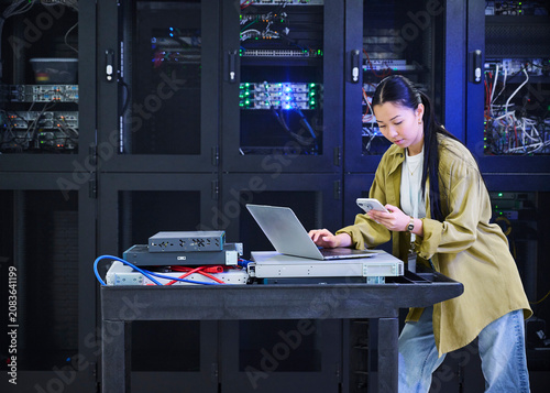 Asian Female Cybersecurity Professional Working in Data Center