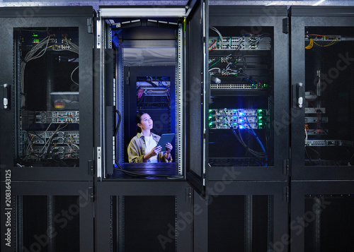 Asian Female Engineer Working in Modern Data Center