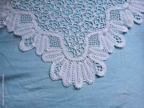 A white lace napkin lies on a blue cloth