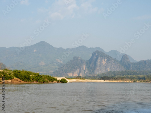 Mekong River Journey Through Laos with Karst Mountains Backdrop