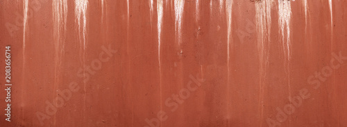 Terracotta textured wall showing white dripping streaks