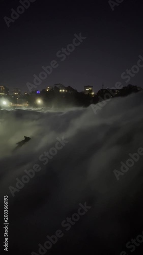SCHAFFHAUSEN, SWITZERLAND - OCTOBER 11, 2025: Night view of the Rhine Falls area with illuminated riverside, trees and buildings in Schaffhausen, Switzerland.
