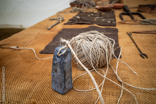 Schilderij op canvas Ancient roman lead plumb bob and twine ball on burlap.