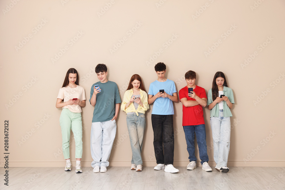 Obraz premium Group of teenagers with different smartphones indoors