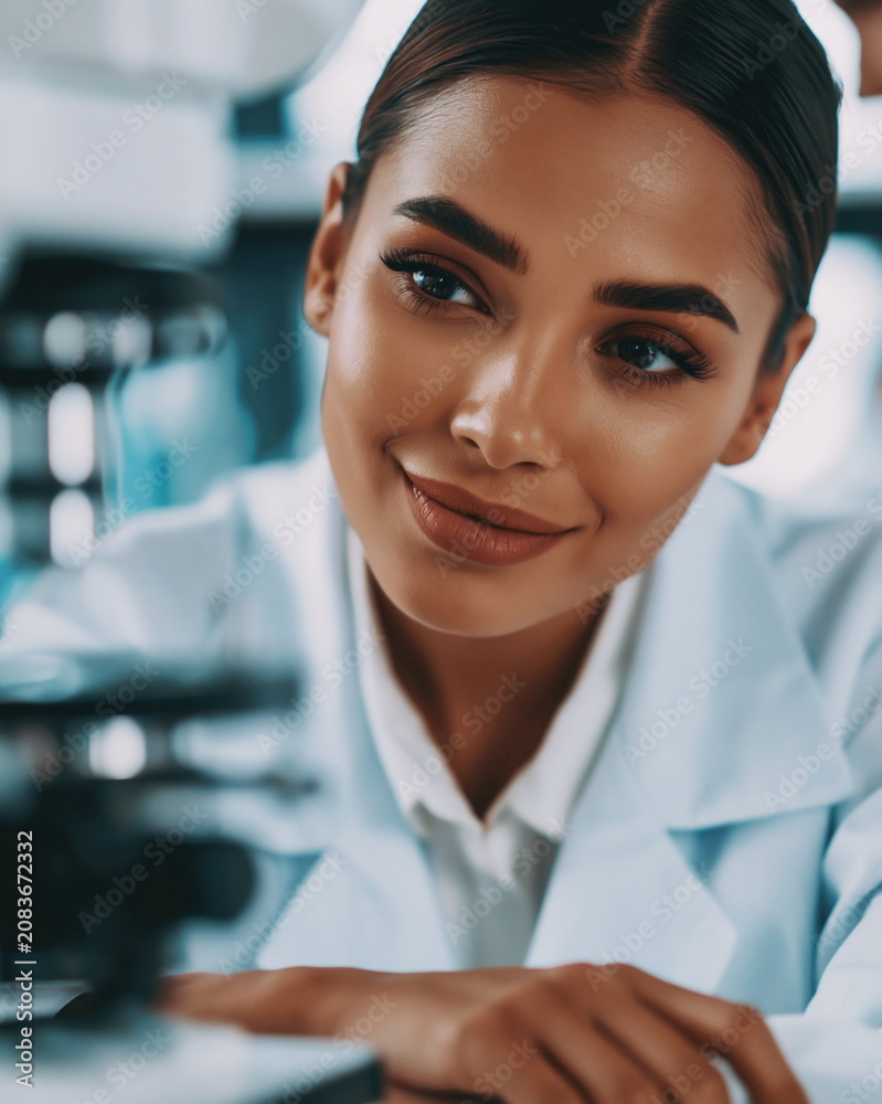 Fototapeta premium Focused Female Scientist Analyzing Advanced Robotics in High-Tech Laboratory with Ambient Lighting and Innovative Equipment