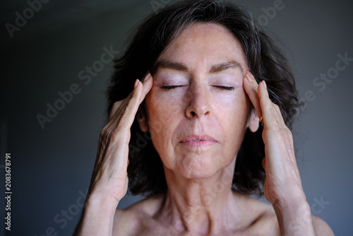 Fotografie front view of Senior woman relieving stress with temple massage