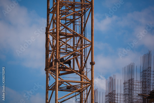 Obraz na plátně Close-up of a yellow tower crane jib end against clear blue sky with large copy