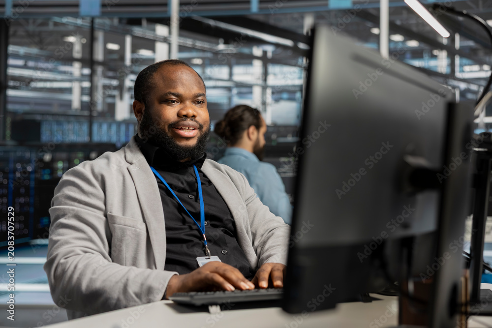 Fototapeta premium Pleased data center worker celebrates a successful server software update in a data center.