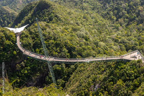 Aerial view of the iconic Langkawi Sky Bridge suspended over lush green rainforest mountains in Malaysia. A popular tourist attraction and architectural marvel, perfect for travel, adventure, eco-tour
